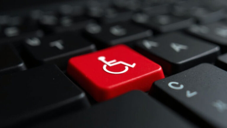 A closeup of a computer keyboard with an accessibility symbol (the wheelchair symbol) on a red button 800